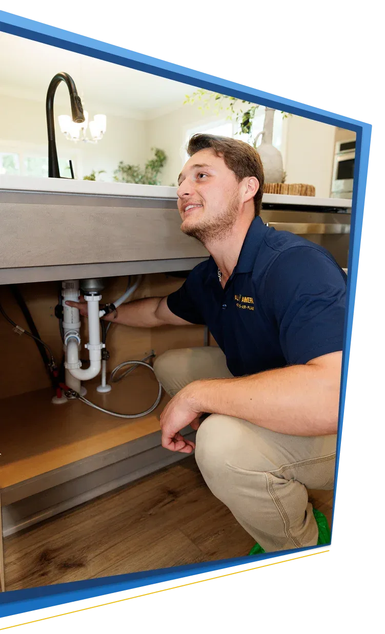 All American Heating, Air & Plumbing technician working on plumbing under a kitchen sink