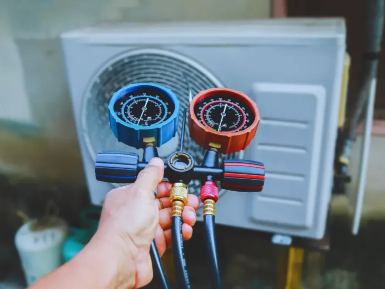 Technician testing refrigerant level on an HVAC system