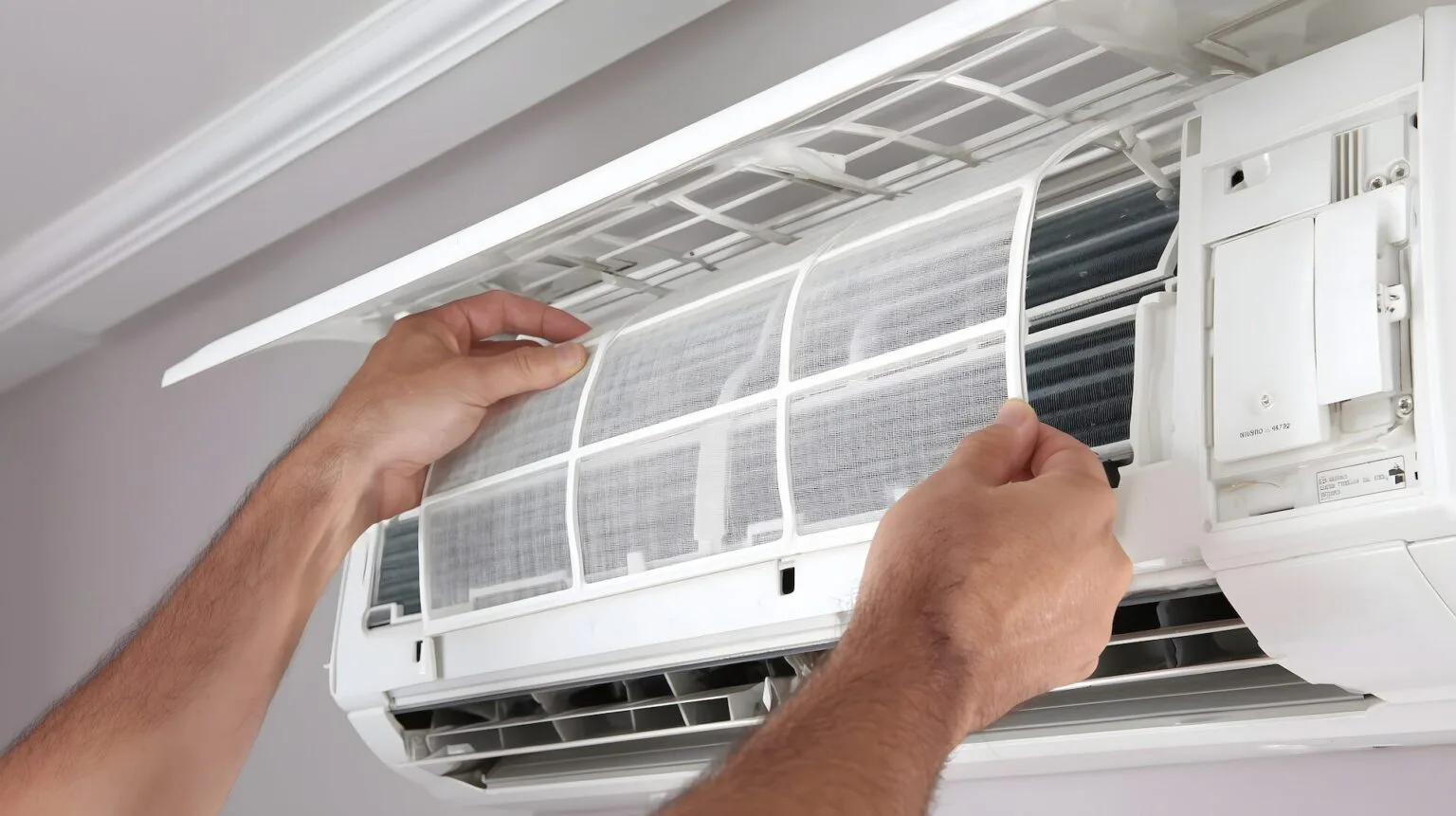 Technician cleaning a mini-split AC indoor unit filter