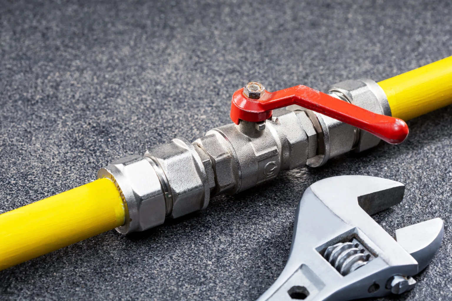 Gas tap connected to a yellow gas pipe and wrench, gas pipeline repair concept