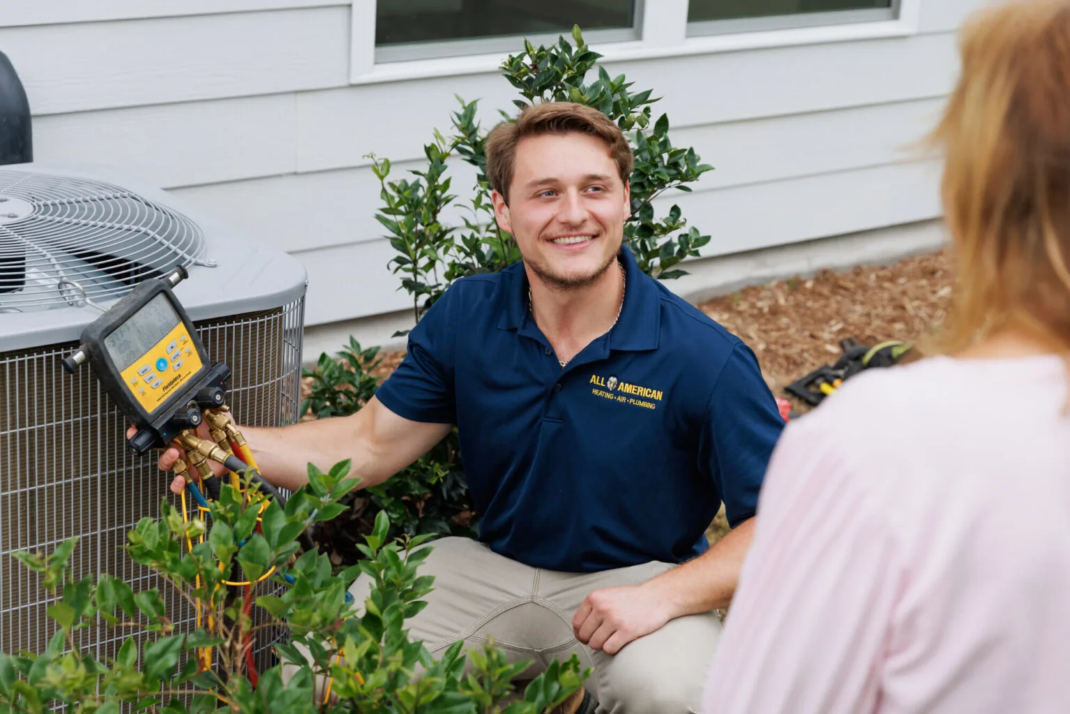 AC maintenance technician using gauges